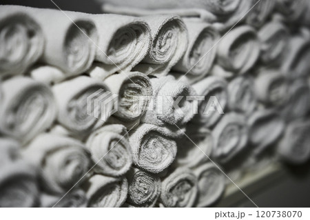 Neatly rolled white towels stacked in a clean facility during daytime 120738070