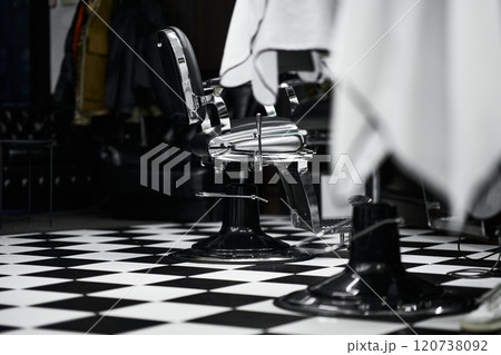 Vintage barber chairs and checkered floor in a classic barbershop setting Vintage barber chairs and checkered floor in a classic barbershop setting 120738092