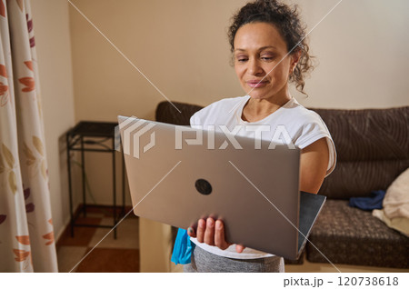 Woman using laptop at home for remote work session 120738618