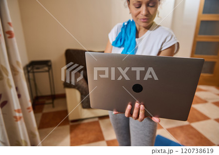 Woman using laptop for online workout at home 120738619