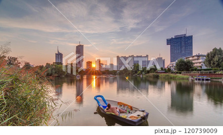 Sunset over Vienna international center skyscrapers with Kaiserwasser lake reflection view timelapse 120739009