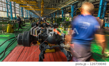 Conveyor assembly stage the body of tractor at big industrial factory timelapse Conveyor assembly stage the body of tractor at big industrial factory timelapse 120739040