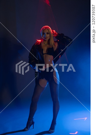 Stylish model poses with confidence in dramatic lighting at night Stylish model poses with confidence in dramatic lighting at night 120739387