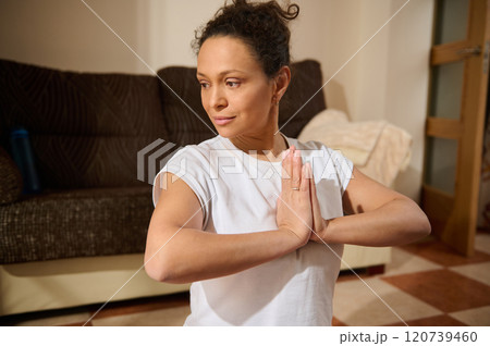 Woman practicing yoga meditation in cozy home setting Woman practicing yoga meditation in cozy home setting 120739460