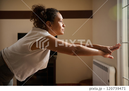 Woman practicing yoga indoors focusing on balance and serenity Woman practicing yoga indoors focusing on balance and serenity 120739471