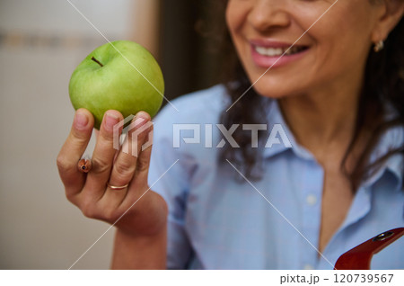 Woman smiling while holding a fresh green apple 120739567