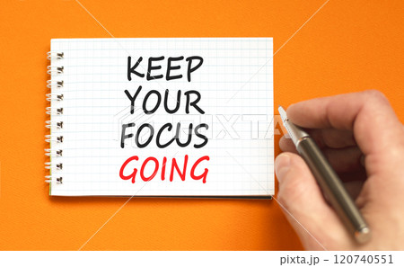 Keep your focus going symbol. Concept words Keep your focus going on beautiful white note. Beautiful orange background. Businessman hand. Business and keep your focus going concept. Copy space. 120740551