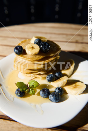 Delicious stack of pancakes with bananas and blueberries 120740897