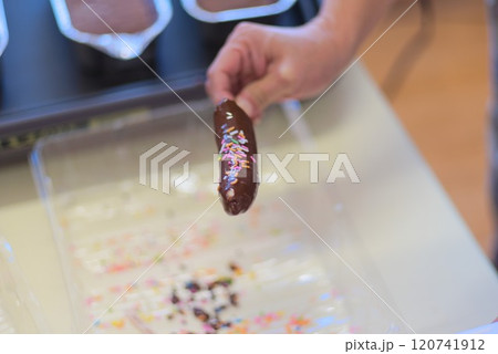 チョコバナナにカラースプレーをかけているシーン 120741912