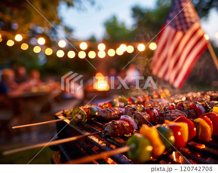 Grilled Kebabs on a Barbecue with a Blurred American Flag in the Background 120742708