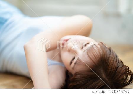 フローリングに寝転ぶ若い女性 フローリングに寝転ぶ若い女性 120745767