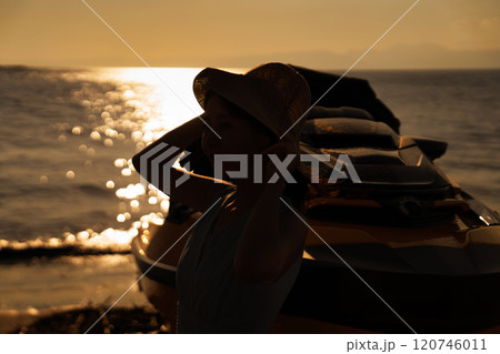 海の夕日と女性のシルエット 120746011
