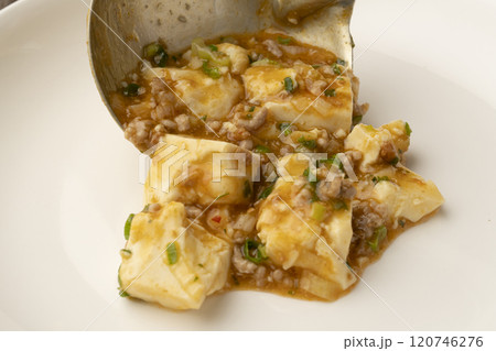 麻婆豆腐をおたまで皿に盛り付ける 120746276