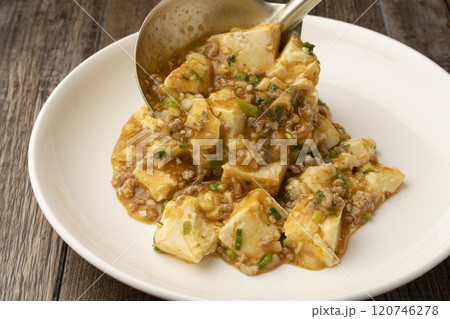 麻婆豆腐をおたまで皿に盛り付ける 麻婆豆腐をおたまで皿に盛り付ける 120746278