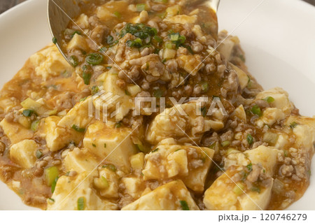 麻婆豆腐をおたまで皿に盛り付ける 麻婆豆腐をおたまで皿に盛り付ける 120746279