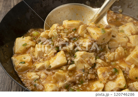 麻婆豆腐をおたまで皿に盛り付ける 麻婆豆腐をおたまで皿に盛り付ける 120746286