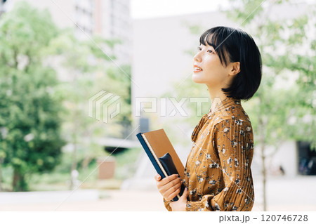 キャンパスを背景にした笑顔の大学生　 120746728