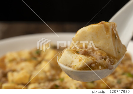 麻婆豆腐　ゆげの立った麻婆豆腐をレンゲで持ち上げる 120747989