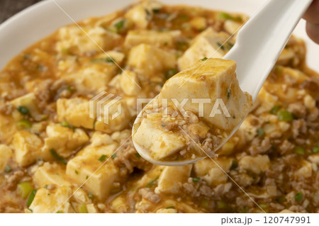 麻婆豆腐　ゆげの立った麻婆豆腐をレンゲで持ち上げる 120747991