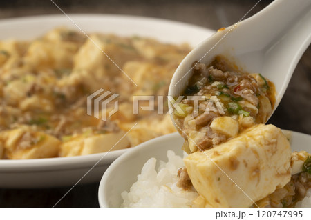 麻婆豆腐　ゆげの立った麻婆豆腐をレンゲで持ち上げる 120747995