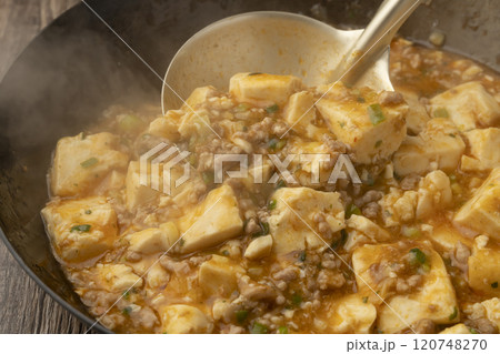 麻婆豆腐をおたまで皿に盛り付ける 麻婆豆腐をおたまで皿に盛り付ける 120748270