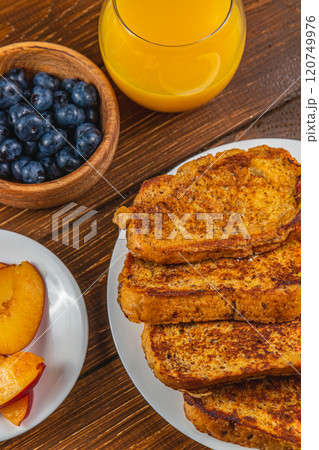 French toast on a plate with blueberries, orange juice, nectarine for breakfast 120749976