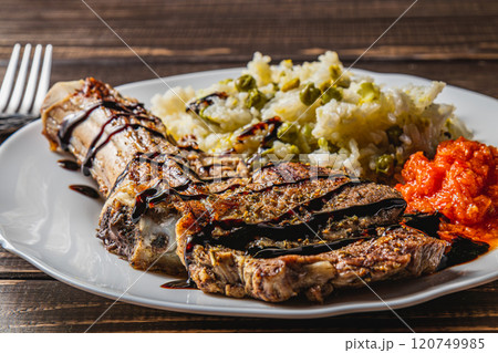 entrecote on the bone with rice and vegetables and adjika on a white plate 120749985