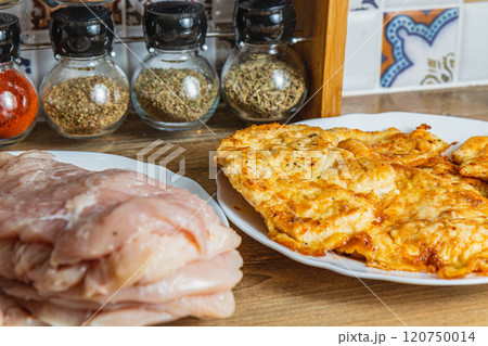 the process of cooking chicken chops with already fried chops in the background 120750014