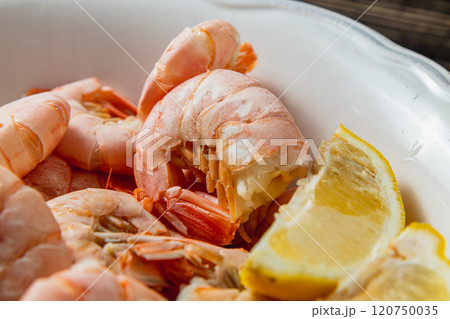 Tiger king prawns cooked and seasoned with lemon, on a wooden table Tiger king prawns cooked and seasoned with lemon, on a wooden table 120750035