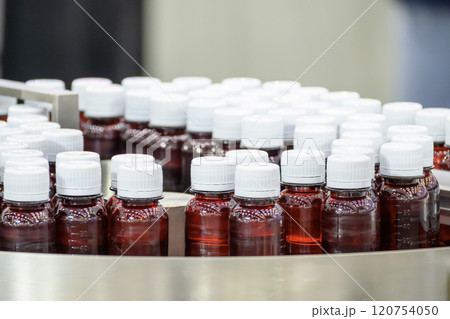 The red drug bottles on the conveyor belt for filling process. The red drug bottles on the conveyor belt for filling process. 120754050