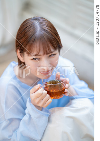 紅茶を飲むフェミニンな雰囲気の若い女性 120754778