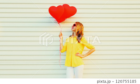 Beautiful happy smiling young woman with bunch of red heart shaped balloons on white background Beautiful happy smiling young woman with bunch of red heart shaped balloons on white background 120755185