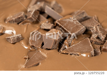 Chocolate pieces in melted milk chocolate. 120755220