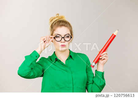 Woman confused thinking, big pencil in hand 120756613