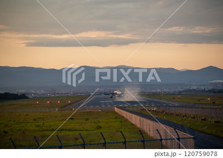 夕暮れの飛行場に着陸する飛行機 夕暮れの飛行場に着陸する飛行機 120759078