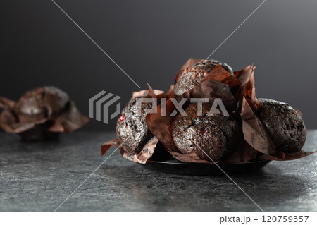 Dark chocolate muffins on a black table. 120759357