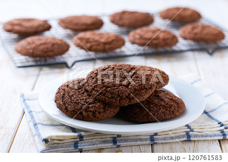 Chocolate brownie cookies with cracks in a ceramic bowl on a white table, selective focus. 120761583