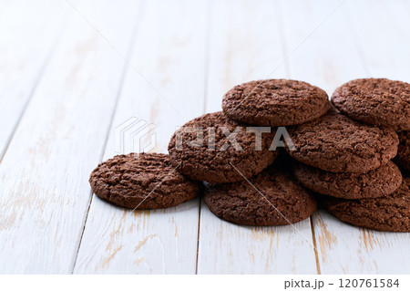 Heap of chocolate cookies  on a white table, with copy space for text. 120761584