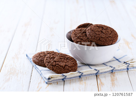 Chocolate brownie cookies with cracks in a ceramic bowl on a white table, selective focus. 120761587