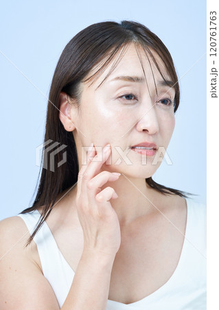 疲れた表情でスキンケアをするミドル世代の女性 疲れた表情でスキンケアをするミドル世代の女性 120761763
