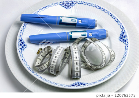 Ozempic Insulin injection pen or insulin cartridge pen for diabetics on a white plate. 120762575