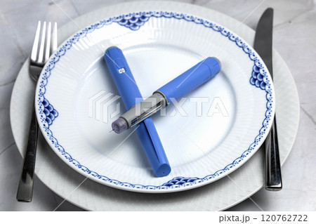 Ozempic Insulin injection pen or insulin cartridge pen for diabetics on a white plate. 120762722