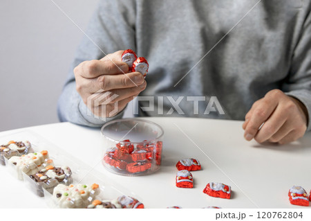 Christmas chocolates. Chocolate Christmas trees and Santa Claus. Mans hands hold chocolate. Christmas chocolates. Chocolate Christmas trees and Santa Claus. Mans hands hold chocolate. 120762804