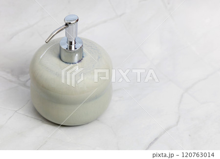 Ceramic soap dispenser and folded towel on white marble background. Ceramic soap dispenser and folded towel on white marble background. 120763014