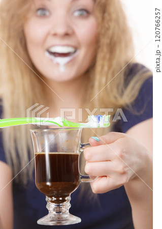 Happy woman holding toothbrush and coffee Happy woman holding toothbrush and coffee 120766257