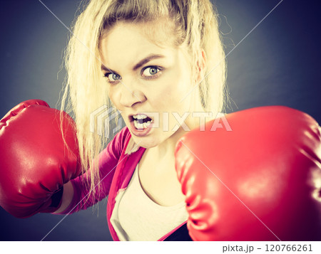 Angry woman wearing boxing gloves 120766261