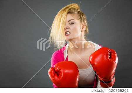 Angry woman wearing boxing gloves 120766262