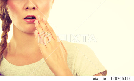 Upset teenage woman with hand close to lips 120766318