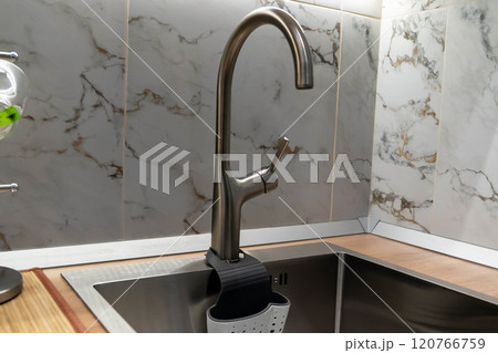 Modern kitchen faucet with sponge holder and marble tile backsplash 120766759