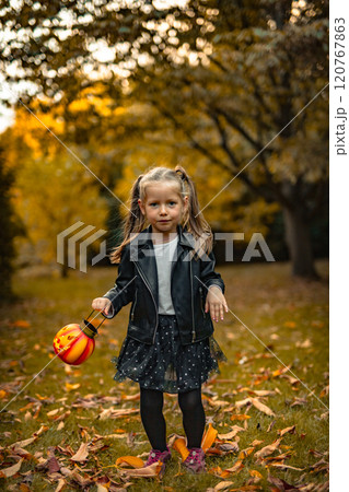 Happy girls 5 years on Halloween with pumpkins in park 120767863